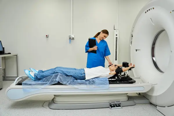 Um médico qualificado em um casaco de laboratório suporta um paciente deitado em uma máquina de ressonância magnética, garantindo conforto. — Fotografia de Stock