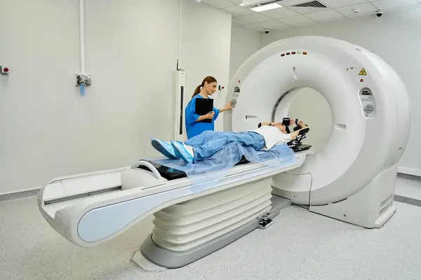 Female doctor guides patient into MRI machine for a medical examination in a hospital. — Stock Photo