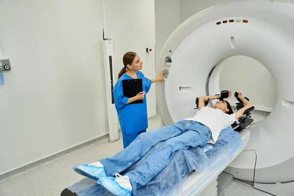 Dedicated doctor provides support to patient during MRI scan in a hospital environment. — Stock Photo