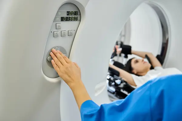 A doctor in a lab coat operates an MRI machine while a patient is being scanned, ensuring safety. — Stock Photo