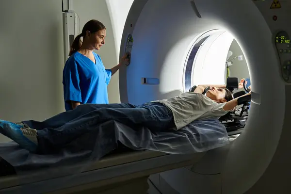 A dedicated female doctor guides a patient through a diagnostic MRI procedure in a hospital. — Stock Photo