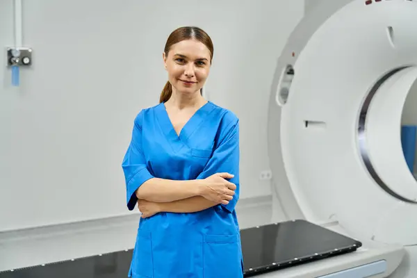 Médica está confiante ao lado de uma máquina de ressonância magnética em um hospital, mostrando experiência. — Fotografia de Stock