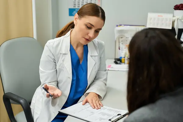 Un gynécologue discute avec une patiente de problèmes de santé lors d'une consultation. — Photo de stock