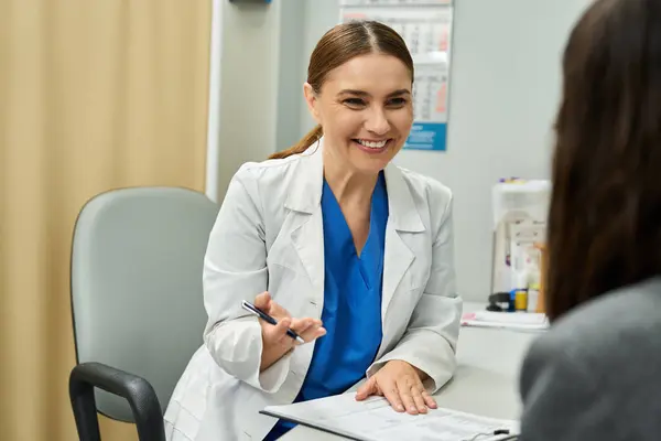 Un médecin dédié effectue un bilan de santé avec une patiente dans une clinique accueillante. — Photo de stock