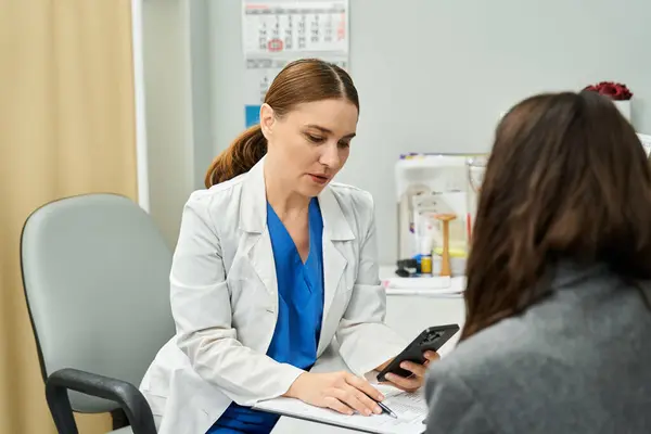 A gynecologist discusses health concerns with a female patient in a clinical setting. — Stock Photo