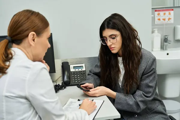 Dans une clinique moderne, une gynécologue parle de santé à sa patiente, assurant ainsi son confort.. — Photo de stock