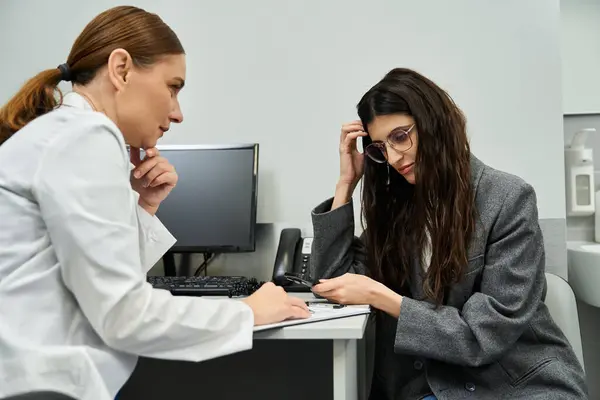 Médico examina a saúde dos pacientes, discutindo preocupações ginecológicas em uma clínica profissional — Fotografia de Stock