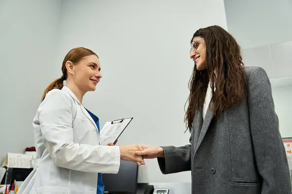 Un gynécologue discute de questions de santé avec une patiente dans une clinique, assurant des soins. — Photo de stock