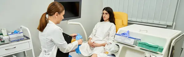 A gynecologist in a lab coat discusses health matters with a female patient, ensuring comfort. — Stock Photo