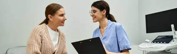 Ein Gynäkologe diskutiert mit einer Patientin in einem modernen Klinikumfeld über reproduktive Gesundheit. — Stockfoto