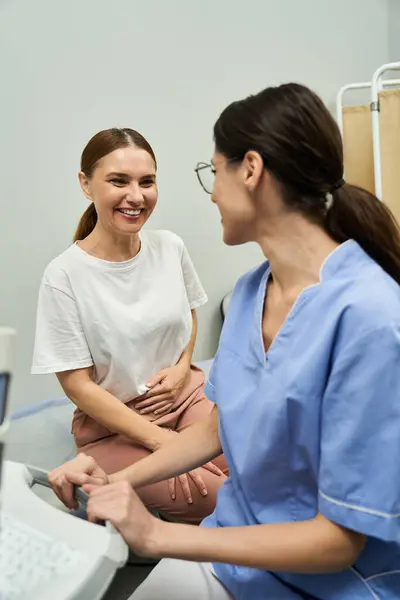 A gynecologist is engaging with a smiling patient during a health checkup in a clinic. — Stock Photo