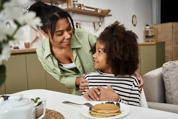 A mother and daughter share a joyful moment while enjoying pancakes together. — Stock Photo