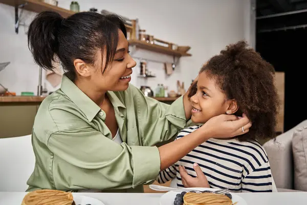 A loving mother shares a fun breakfast with her cheerful daughter, making lasting memories. — Stock Photo