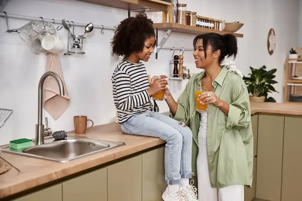 Two caring individuals bond over homemade drinks while sharing delightful laughter in the kitchen. — Stock Photo