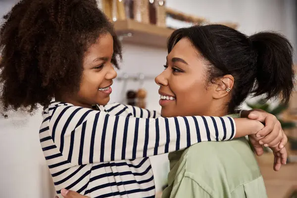 Una madre amorevole sorride amorevolmente mentre sua figlia le avvolge le braccia al caldo. — Foto stock