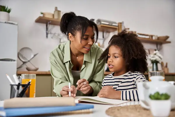A mother joyfully engages with her daughter while sharing a tender moment in the kitchen. — Stock Photo