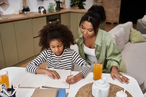 A mother watches proudly as her daughter draws, fostering creativity and connection at home. — Stock Photo