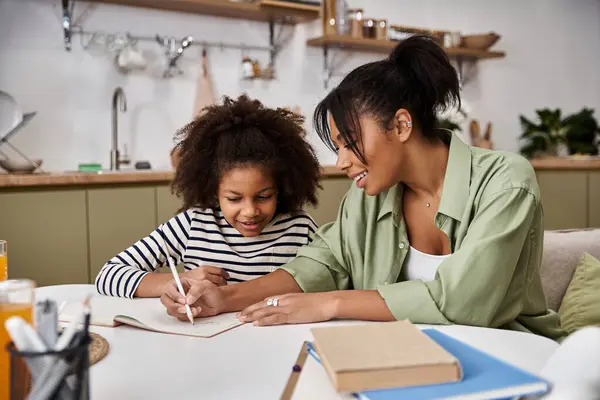 Eine Mutter führt ihre Tochter mit Freude, während sie zu Hause ihre kreative Seite erkunden. — Stockfoto