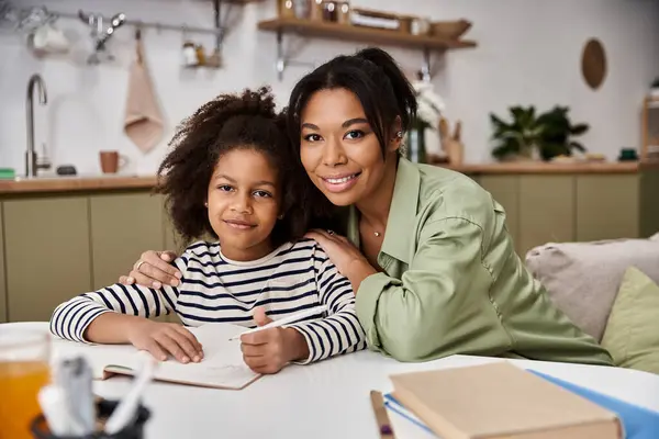 A mother and daughter enjoy crafting together in their cozy modern kitchen setting. — Stock Photo