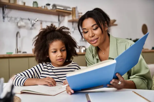 A mother and daughter share a joyful reading session at home, bonding and learning together. — Stock Photo