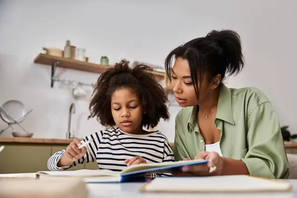 A mother and daughter joyfully explore a colorful book together. — Stock Photo