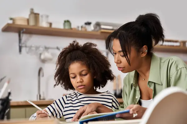 Mother and daughter joyfully explore creativity in their cozy kitchen together. — Stock Photo