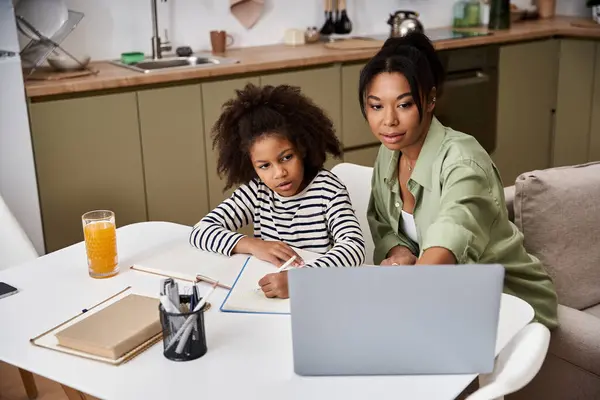 Madre e figlia condividono un momento speciale mentre lavorano insieme ai compiti scolastici a casa.. — Foto stock