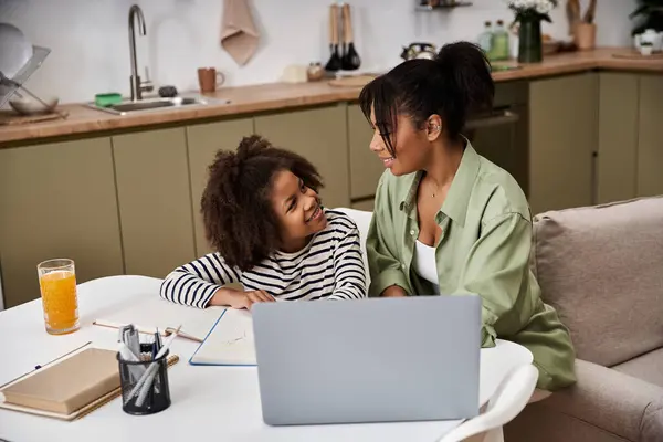 Mother and daughter share a joyful study time at their kitchen table filled with creativity. — Stock Photo