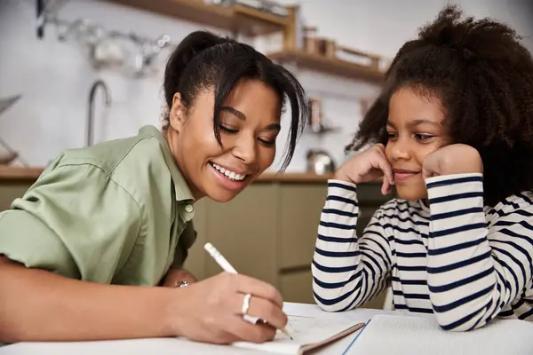 A happy mother shares creative activities with her eager daughter, boosting learning and bonding. — Stock Photo