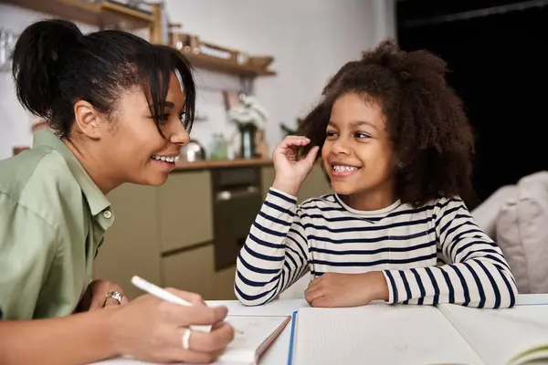 Eine fröhliche Mutter verbindet sich mit ihrer Tochter, während sie kreative Momente zu Hause teilt. — Stockfoto