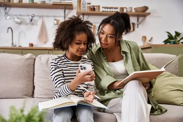 A mother and her daughter share joyful moments while reading and exploring together. — Stock Photo