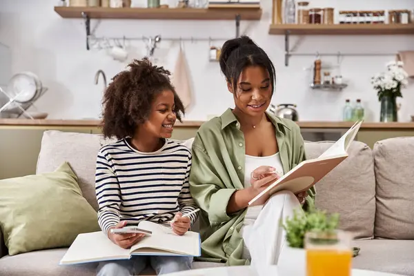 A loving mother shares a story with her smiling daughter in a warm family setting. — Stock Photo