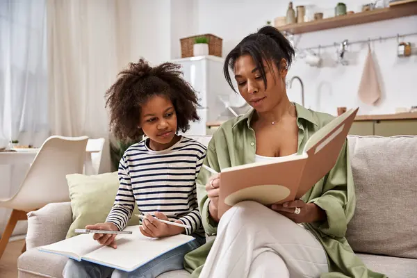 A mother and her little daughter bond while drawing and sharing stories in a warm home setting. — Stock Photo