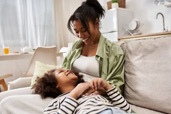 Mother and daughter engage in a heartfelt playful moment, filled with laughter and love. — Stock Photo