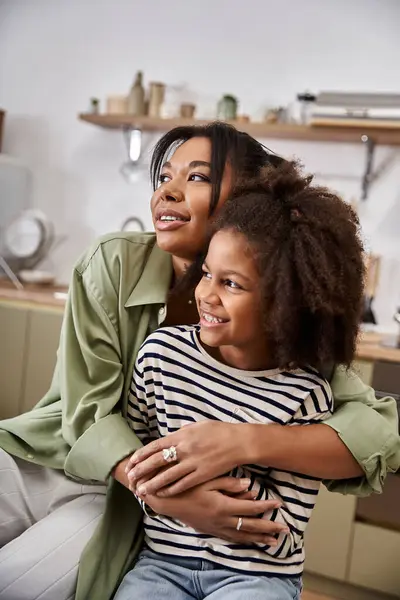 A mother embraces her joyful daughter in a modern kitchen filled with warmth and love. — Stock Photo