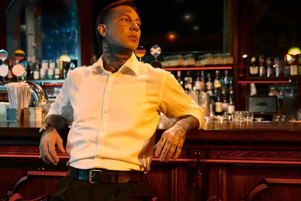 A tattooed young man relaxes at the bar, exuding confidence during a night out. — Stock Photo