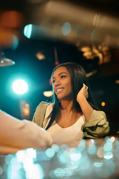 Stylish multicultural couple shares laughter and emotions during a cozy bar date night. — Stock Photo