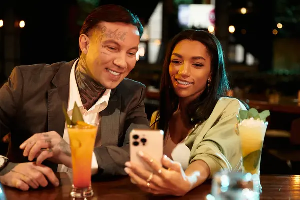 A young multicultural couple shares smiles while taking selfie during a night out. — Stock Photo