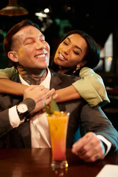 A young couple enjoys a joyful evening together at a vibrant bar setting. — Stock Photo