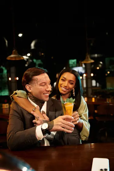 Young couple shares laughter and drinks during a lively night out at the bar. — Stock Photo