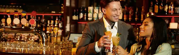 Young couple shares laughter and drinks at a bar, celebrating their special night out. — Stock Photo
