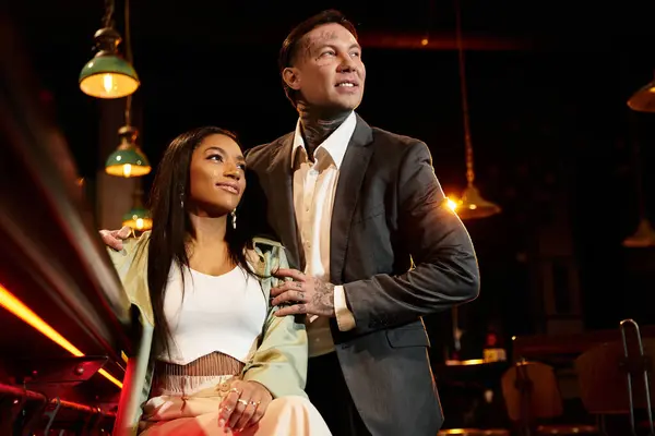 A young couple shares a special evening in a vibrant bar, creating lasting memories. — Stock Photo