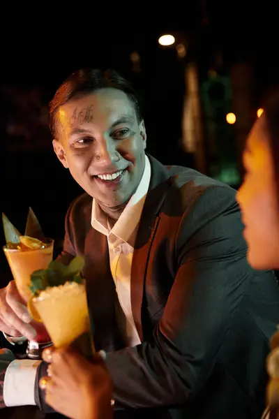 Two young adults share a joyful evening together at a bar, embodying love and diversity. — Stock Photo
