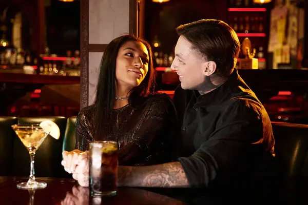Young couple shares a lovely moment on a night out at a lively bar, enjoying each others company. — Stock Photo