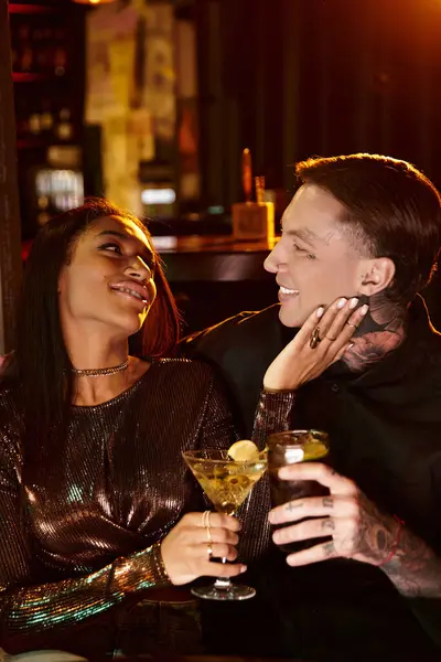 A beautiful young couple shares drinks and laughter on their evening date at a lively bar. — Stock Photo