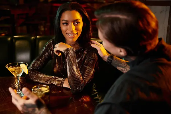 A young couple shares laughter and connection at a lively bar during a night out. — Stock Photo