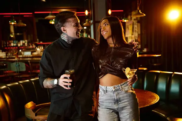 A young couple shares laughter and drinks at a vibrant bar, enjoying their date night. — Stock Photo