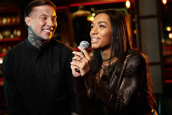 A couple shares a joyful moment while engaging in karaoke, surrounded by vibrant nightlife. — Stock Photo