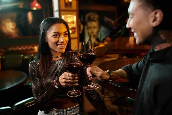 Young couple toasting with glasses of wine during their vibrant night out in the bar. — Stock Photo