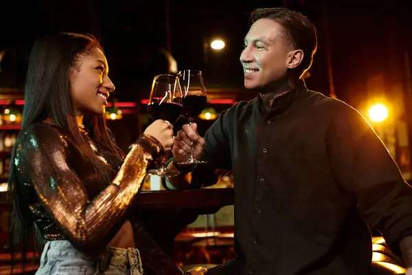 A young couple shares laughter and wine during an intimate evening out, showcasing their love. — Stock Photo